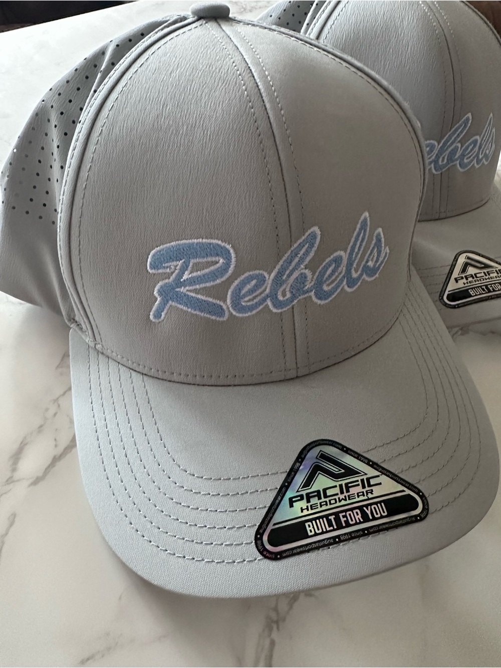 Pacific Headwear “Rebels” Trucker Hat - Light Gray with Light Blue Embroidery